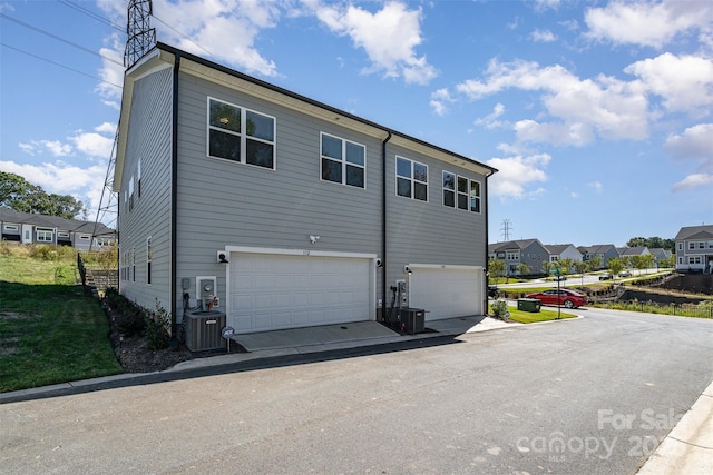 view of side of home featuring a garage and central AC unit