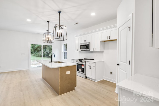 kitchen with white cabinets, a kitchen island with sink, stainless steel appliances, and sink