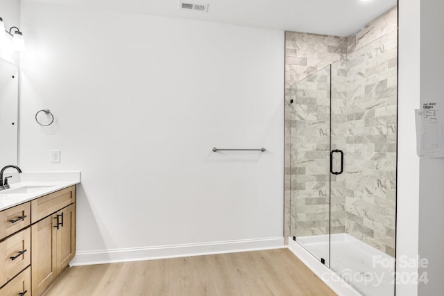 bathroom featuring an enclosed shower, hardwood / wood-style floors, and vanity