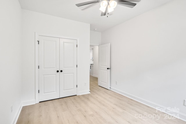 unfurnished bedroom featuring ceiling fan, a closet, and light hardwood / wood-style flooring