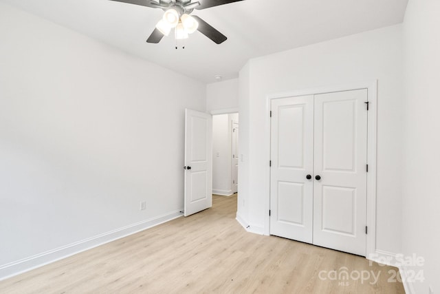 unfurnished bedroom featuring ceiling fan, light hardwood / wood-style flooring, and a closet