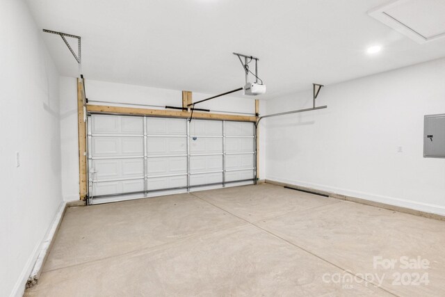 garage with a garage door opener and electric panel