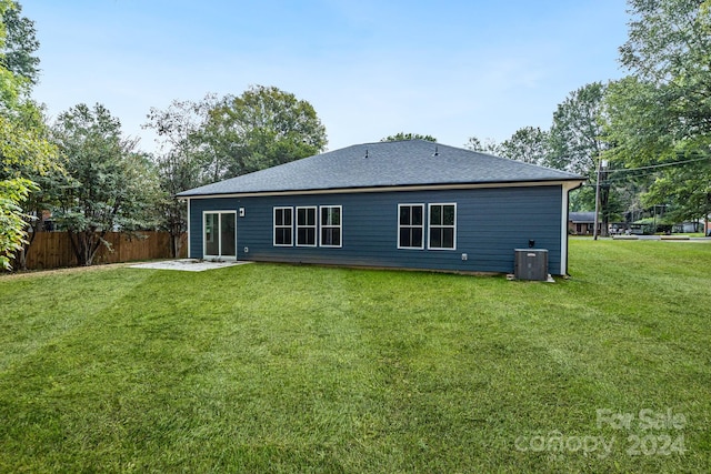 rear view of house featuring a yard and central AC unit