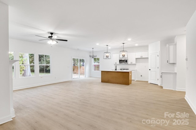 unfurnished living room featuring recessed lighting, baseboards, light wood-type flooring, and a ceiling fan