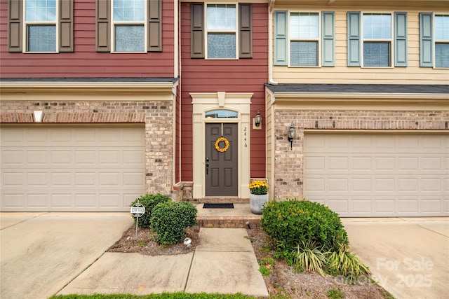 view of front facade with a garage, driveway, and brick siding