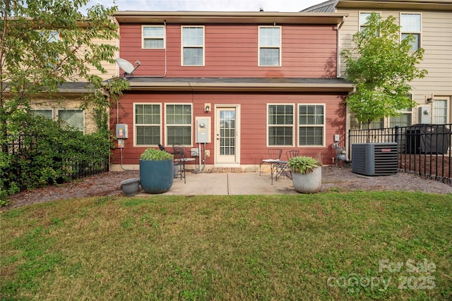 rear view of property featuring a yard, cooling unit, fence, and a patio