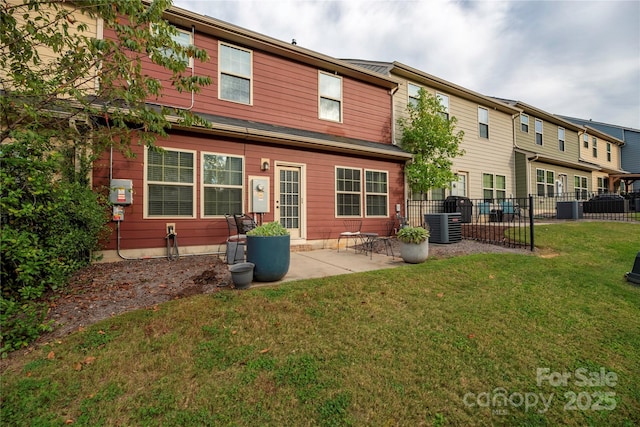 rear view of house with a yard, central air condition unit, fence, and a patio