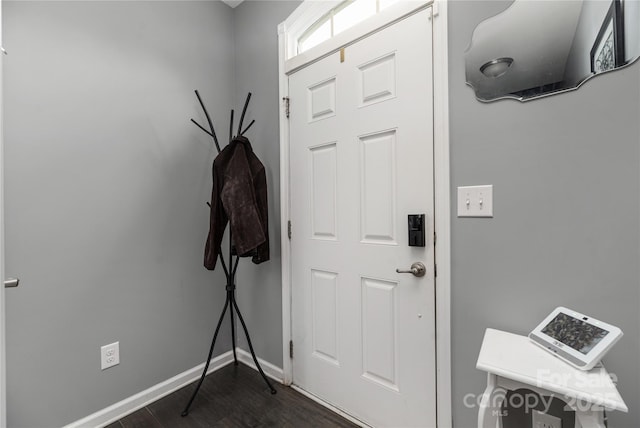 foyer entrance featuring baseboards and dark wood finished floors