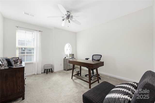 office space featuring a healthy amount of sunlight, visible vents, and light colored carpet