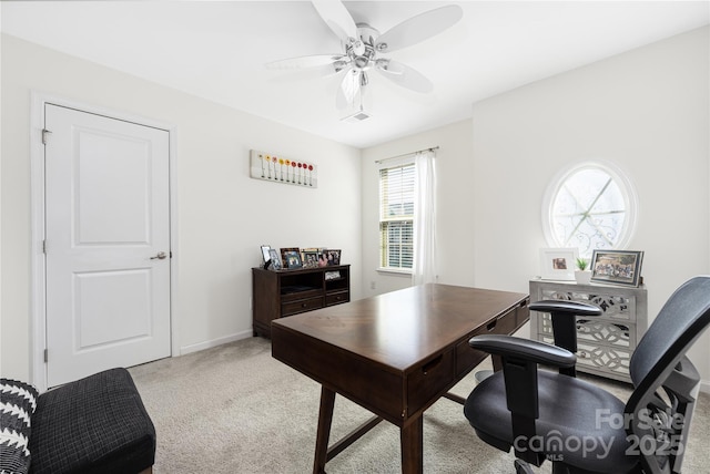 home office featuring light colored carpet, ceiling fan, and baseboards