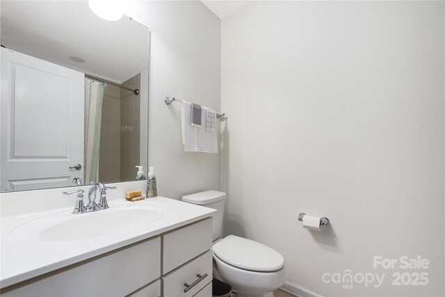 full bath featuring a shower with shower curtain, vanity, and toilet