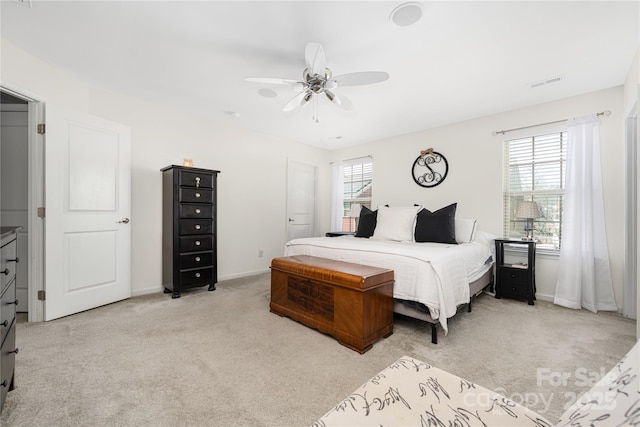 bedroom with light colored carpet, visible vents, ceiling fan, and baseboards