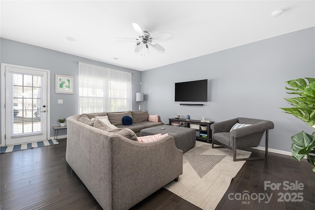 living room featuring ceiling fan, baseboards, and wood finished floors