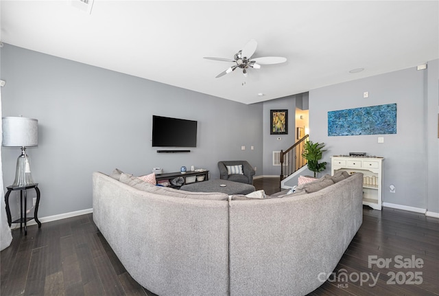 living area with dark wood-style floors, a ceiling fan, baseboards, and stairs