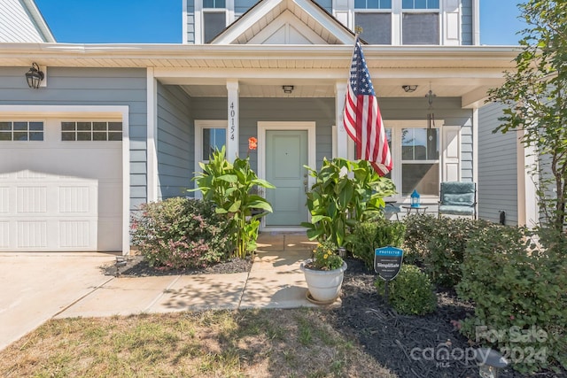 doorway to property with a porch and a garage