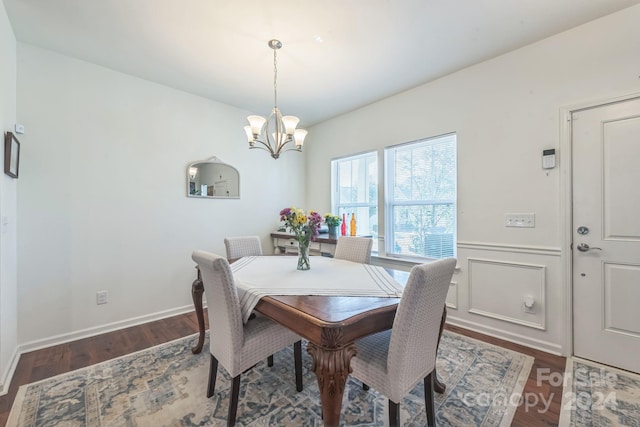 dining area with dark hardwood / wood-style floors and a chandelier