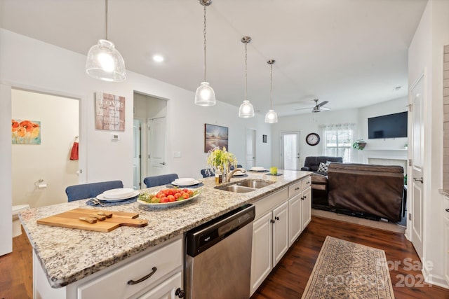 kitchen with ceiling fan, sink, dark wood-type flooring, stainless steel dishwasher, and a center island with sink