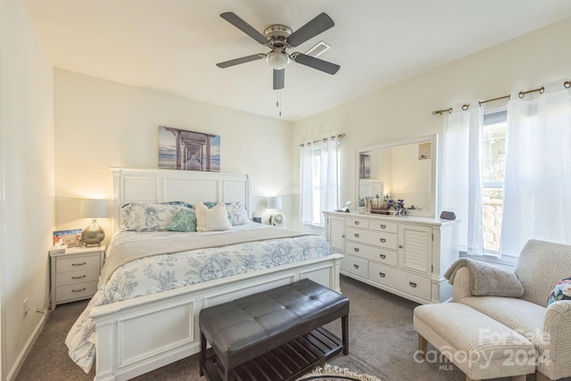 bedroom with multiple windows, ceiling fan, and dark colored carpet