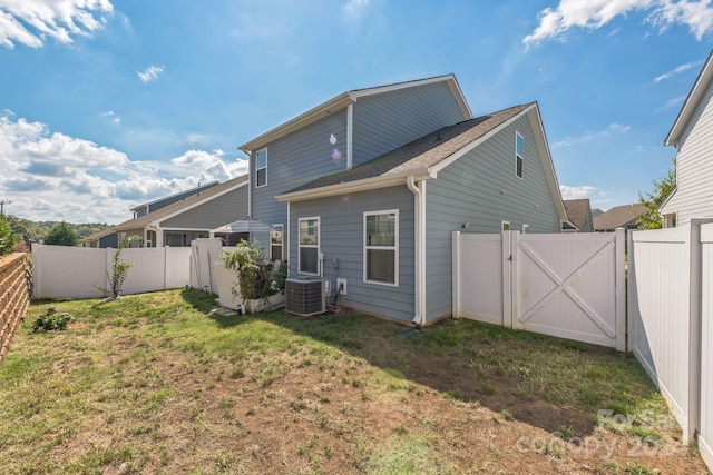 back of house with a lawn and central AC