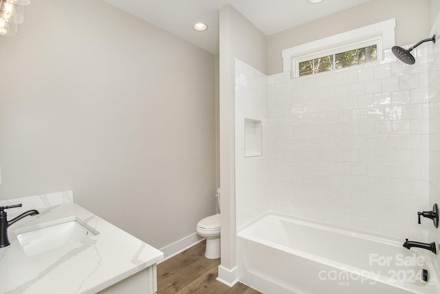 full bathroom with toilet, tiled shower / bath combo, vanity, and hardwood / wood-style floors