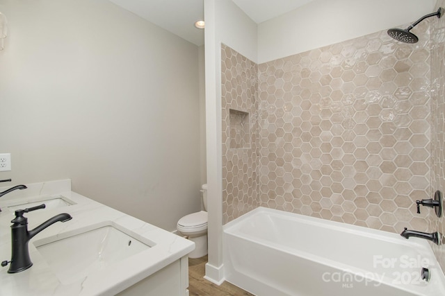 full bathroom with toilet, tiled shower / bath combo, vanity, and wood-type flooring