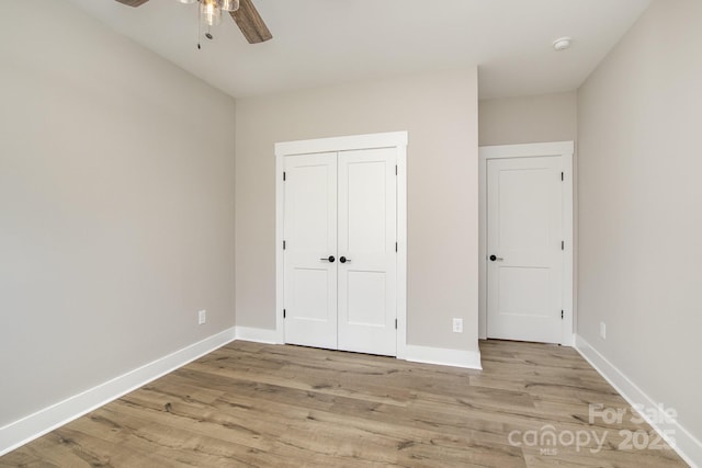 unfurnished bedroom with wood finished floors, baseboards, a closet, and a ceiling fan
