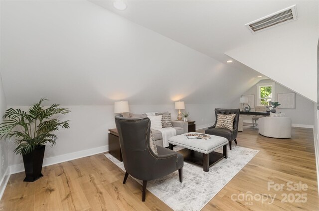 living area with vaulted ceiling, baseboards, light wood finished floors, and recessed lighting