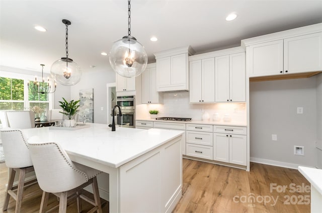 kitchen with double oven, white cabinets, tasteful backsplash, recessed lighting, and light wood-type flooring