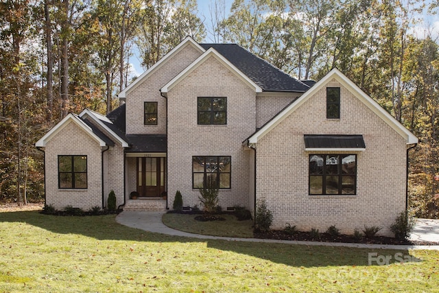 view of front facade with a front lawn and brick siding