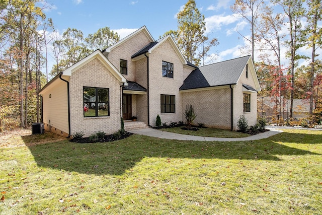 view of front facade featuring brick siding, cooling unit, and a front yard