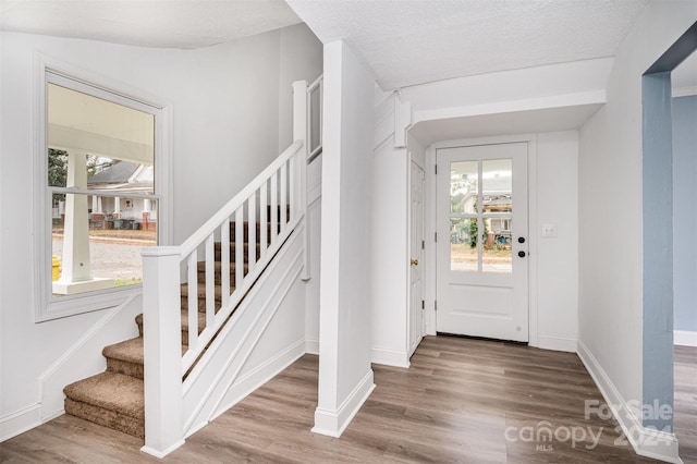 foyer entrance featuring wood-type flooring, plenty of natural light, and a textured ceiling