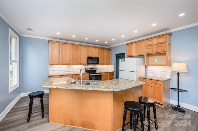 kitchen featuring stainless steel electric range, wood-type flooring, a center island with sink, and white refrigerator