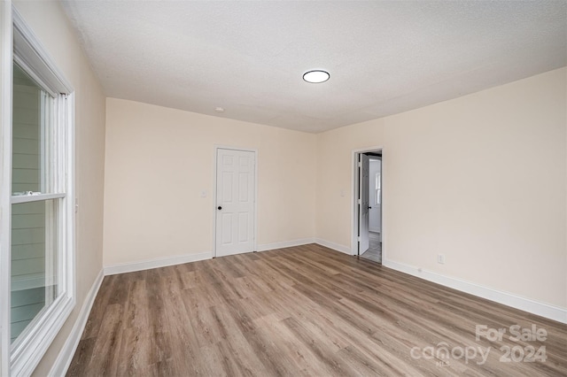 empty room featuring light hardwood / wood-style floors and a textured ceiling