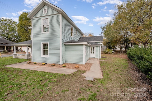 rear view of property with a patio and a yard