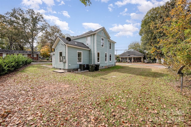 back of house featuring central AC unit and a yard