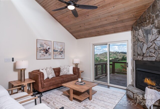 living room featuring high vaulted ceiling, ceiling fan, hardwood / wood-style floors, wood ceiling, and a fireplace