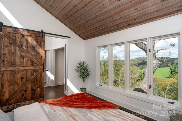 unfurnished bedroom with a barn door, dark hardwood / wood-style floors, wood ceiling, and lofted ceiling