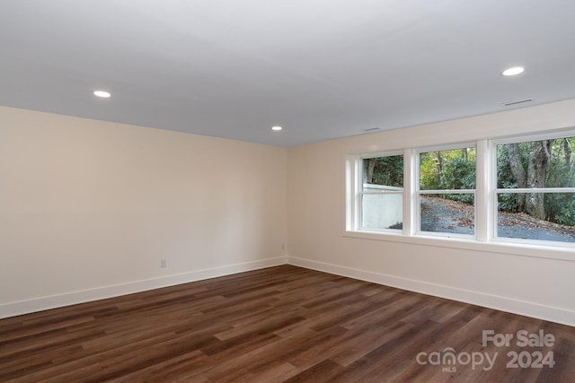 unfurnished room with dark hardwood / wood-style flooring