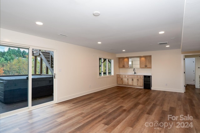 unfurnished living room with sink and dark wood-type flooring