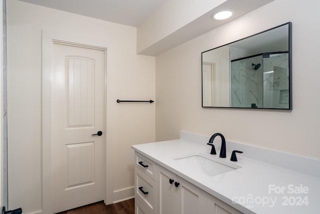 bathroom with a shower with door, hardwood / wood-style flooring, and vanity