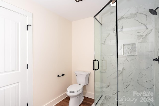 bathroom with walk in shower, hardwood / wood-style flooring, and toilet