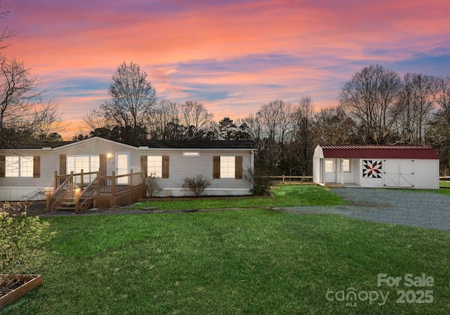 view of front of home with an outdoor structure and a lawn