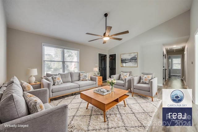 living room with a wealth of natural light, lofted ceiling, light hardwood / wood-style floors, and ceiling fan