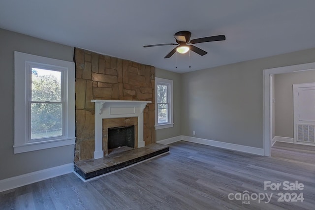 unfurnished living room with hardwood / wood-style floors, a fireplace, and ceiling fan