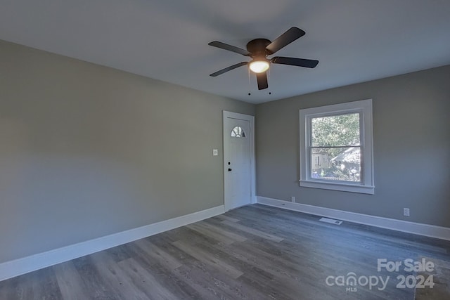 empty room featuring dark wood-type flooring and ceiling fan