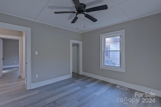 unfurnished room featuring crown molding, light wood-type flooring, and ceiling fan