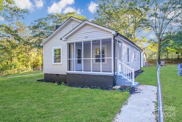 bungalow with a sunroom and a front lawn