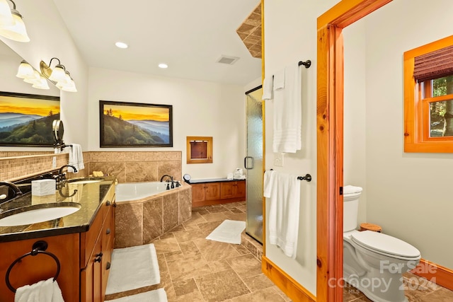 full bathroom featuring vanity, shower with separate bathtub, and toilet