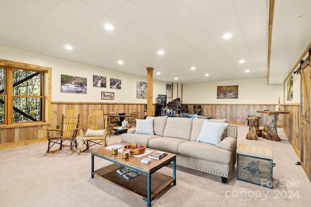 living room featuring wooden walls and light colored carpet