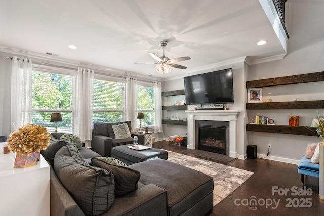 living room with dark hardwood / wood-style flooring, ornamental molding, and ceiling fan